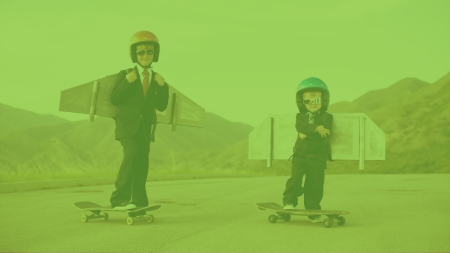 Jungen mit Fliegerbrillen und angeschnallten Flügelchen auf Skateboards